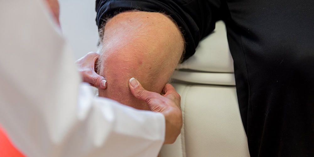 A healthcare professional examining a patient's elbow, focusing on joint care or physical therapy.