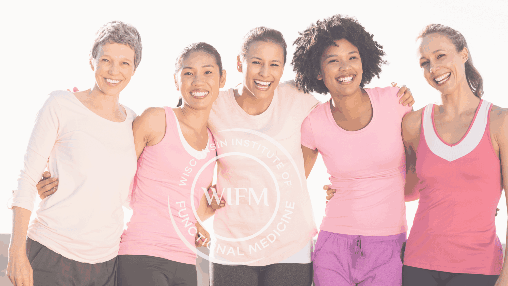 A diverse group of five women in pink activewear smiling and standing close together, symbolizing unity and health.